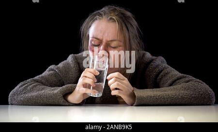 Häusliche Gewalt Opfer von Trinkwasser aus Glas, weibliche Geisel, Entführung Stockfoto