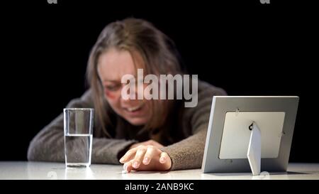 Deprimiert schreiende Dame an Foto unter Antidepressivum, Gewalt Opfer suchen Stockfoto