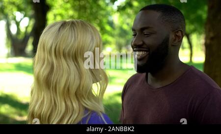 Lächelnd afro-amerikanischer Mann an Freundin suchen, dating Im freien Wochenende im Park Stockfoto