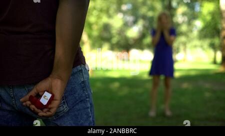 Mann verstecken Engagement Ring hinter, bereit vorzuschlagen, über Antwort beunruhigend Stockfoto