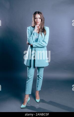 Porträt der jungen Geschäftsfrau im blauen Anzug. Studio dunklen Schoß Stockfoto