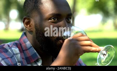 Schwarzer Rüde, Wein trinken, mit Freunden im Park, Zeit auf Picknick entspannen Stockfoto