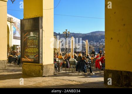 Die Menschen genießen die Sonne auf einem ungewöhnlich warmen Weihnachten in ein Café im Freien in Vittorio Veneto Square, Turin, Piemont, Italien Stockfoto