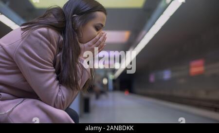 Verzweifelte Frau leiden Angst Angriff an der U-Bahn Station, hilflos Stockfoto