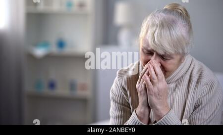 Ältere Dame allein im Pflegeheim Sitzung verärgert und tief Schreien, Einsamkeit Stockfoto