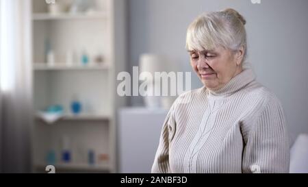 Verärgert ältere Dame sitzt allein in der Krankenpflege Haus und schreien, gesundheitliche Probleme Stockfoto