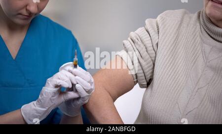 Medizinischer Arbeiter die Injektion zu alte Frau leidet unter Schmerzen, Behandlung Stockfoto