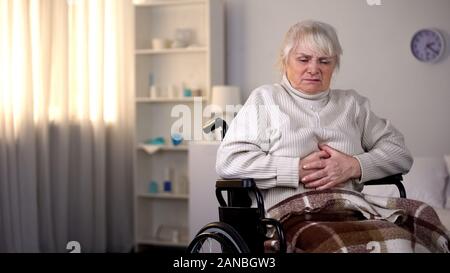 Behinderte alte Frau mit Bauchschmerzen, Gesundheitswesen, Gastritis Stockfoto