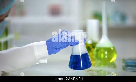 Der Übungsassistent überprüfen Reaktion in Flasche mit blauem Stoff weißer Rauch Stockfoto