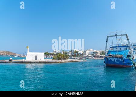 Naxos, Griechenland - 14 August 2019; Griechenland Kykladen Insel Naxos winzige Kapelle auf der Insel in der Mitte des Hafens mit kommerziellen Fischerboot neben p günstig Stockfoto