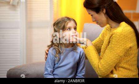 Junge weibliche tröstlich, kleine Tochter, zärtlich berühren Mädchen Gesicht, Nähe Stockfoto