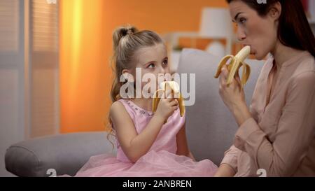 Mutter und Tochter essen Bananen, gesunde Lebensweise, Ernährung, Diät Stockfoto