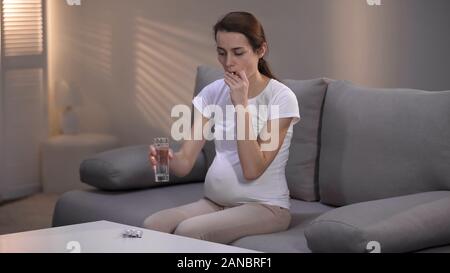 Deprimiert schwangere Frau die Pille, häuslicher Gewalt Opfer im rehab, Armut Stockfoto