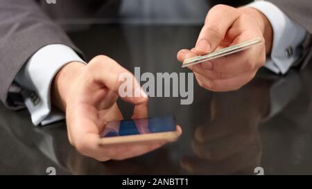 Boss mit Mobile Banking auf dem Smartphone, das Einfügen von Kartennummer, online Zahlung Stockfoto