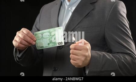 Mann in Anzug hundert Euro bill Brennen, Finanzkrise, Inflation Konzept Stockfoto