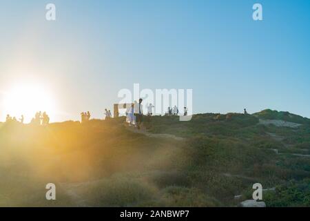 Naxos Griechenland - 12. August 2019; Touristen bis zu Fuß zum Tempel des Apollo für den Sonnenuntergang beleuchteten von Sun Annäherung an der Spitze des Berges. Stockfoto