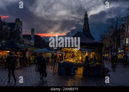 Die Vismarkt im Zentrum von Groningen bei Dämmerung mit im Hintergrund der Aa-Kerk, eines der Wahrzeichen der Stadt, die Niederlande 2019. Stockfoto