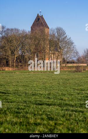 Die Reformierte Kirche, von einem Friedhof umgeben, in Wanswerd steht auf einem Hügel, Die Niederlande 2019. Stockfoto