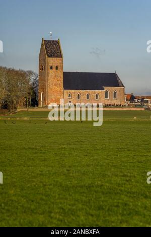 Die Reformierte Kirche, von einem Friedhof umgeben, in Wanswerd steht auf einem Hügel, Die Niederlande 2019. Stockfoto