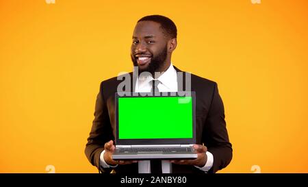 Afrikanisch-amerikanischen Geschäftsmann Holding prekeyed Laptop und lächelnd, Ad-Vorlage Stockfoto