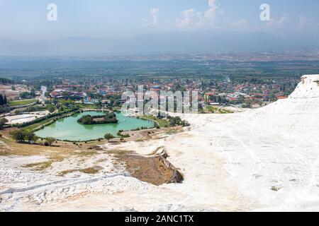 Blick auf die einzigartige Pamukkale natürlicher Komplex mit weißen Klippen, einem smaragdgrünen See, einem malerischen Dorf und einem schönen Tal. Stockfoto