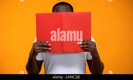 Afro-amerikanischer Mann lesen Buch aufgeregt, studieren und Selbstentwicklung, close-up Stockfoto