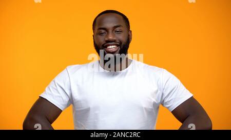 Happy afroamerikanischen männlichen Kamera lächelnd auf gelbem Hintergrund Stockfoto