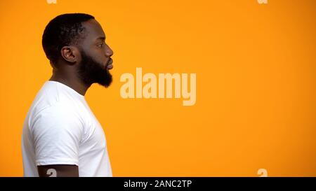 Seitenansicht des jungen Afro männlich gegen gelben Hintergrund, Werbung Stockfoto