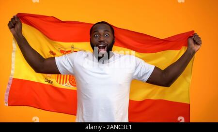 Freundliche schwarz Sport fan Holding spanische Flagge Zujubeln für Nationalmannschaft Sieg Stockfoto