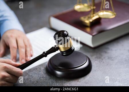 Nahaufnahme einer menschlichen Hand markante Mallet Vor der Goldenen Waage Stockfoto