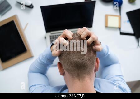 Hohe Betrachtungswinkel der Jungen betonte Geschäftsmann Vor Laptop am Schreibtisch Stockfoto