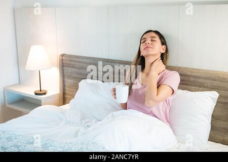 Attraktive Frau mit geschlossenen Augen, eine Tasse Kaffee oder Tee. Frau Entspannung nach einem anstrengenden Tag Stockfoto