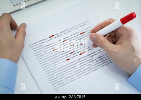 In der Nähe von Roter Stift markieren Fehler während der rechtschreibprüfung Text auf Papier Stockfoto