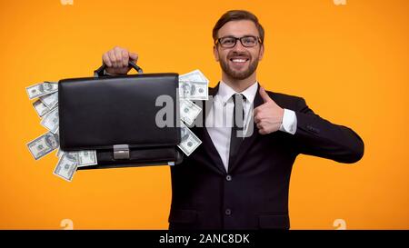 Mann zeigt Fall mit Geld verpackt, Thumbs-up, Darlehen, einfache Anrechnung Stockfoto