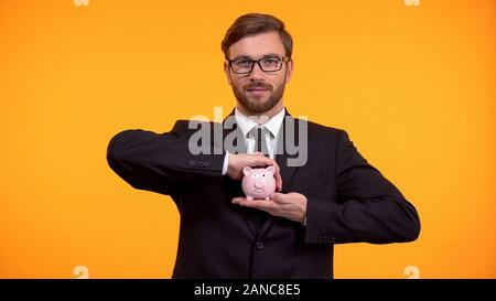 Mann hält piggy Bank, Banking Investment und Finanzen, die Sorge um die Zukunft Stockfoto