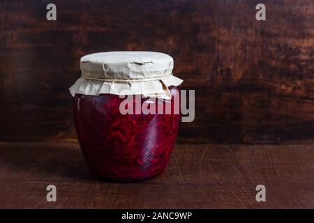 Hausgemachten Sauerkraut. Fermentierter Lebensmittel. Kohl Salat mit Rüben in einem Glas auf einem dunklen Hintergrund. Kopieren Sie Platz. Stockfoto