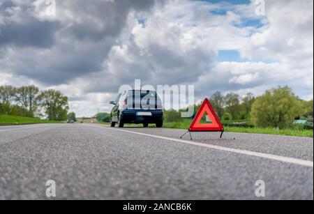 Warndreieck vor einem kaputten Auto auf einer Landstraße Stockfotografie -  Alamy