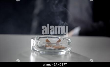 Aschenbecher voller Zigarettenkippen auf Tabelle, ungesunde Gewohnheit, Nikotinabhängigkeit Stockfoto