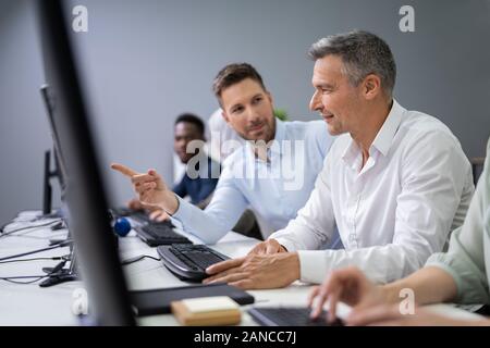 Junge Unternehmer Helfen seiner Kollegen in die Tätigkeit des Amtes Stockfoto