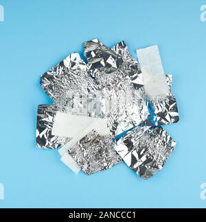 Verschiedene zerknittert weißes Papier und Folie verwendet candy Wrapper auf blauem Hintergrund, Ansicht von oben Stockfoto