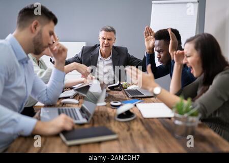 Unternehmen Mitarbeiter miteinander streiten am Arbeitsplatz im Büro Stockfoto