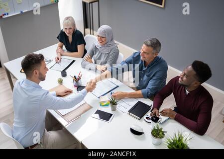 Geschäftsleute, die zitternden Händen nach dem Beenden einer Sitzung im Stockfoto