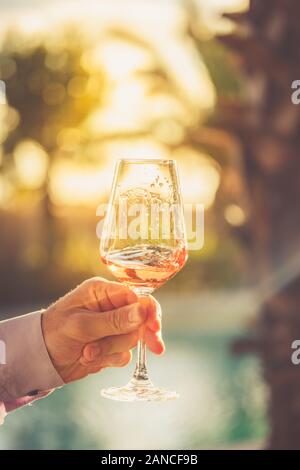 Wabernde Glas Rose Wein bei Weinproben. Konzept der Rose Wein. Vertikale, warme Toning Stockfoto