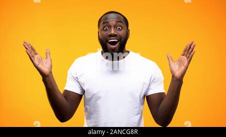 Aufgeregt männlichen Schwarzen suchen Kamera auf hellen Hintergrund, überraschung Reaktion, Nachrichten Stockfoto