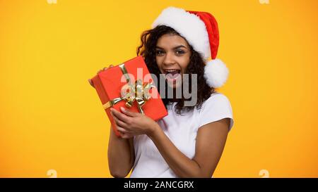 Attraktive Frau mit roter Geschenkbox aufgeregt, neues Jahr vorhanden Begrüßung Stockfoto