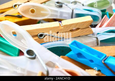 Nahaufnahme von Kunststoff- und Holzkleidern in einem Korb in den Farben Gelb, Rot, Grün, Purpur und Blau. Konzept für Waschen und montagsblues Stockfoto