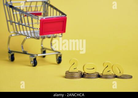 Holzfiguren 2020 auf Stapel von Münzen, die in der Nähe von einem Trolley. Close Up. Stockfoto