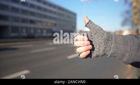 Männliche angezeigt Thumbs up Auto zu fangen, per Anhalter Fahren und Reisen, Abenteuer Stockfoto