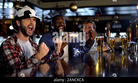 Fröhliche Fußball-Fans unterstützen ihre Mannschaft im Pub glücklich über den Sieg, rest Stockfoto