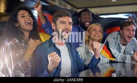 Begeisterte Fans des deutschen Sports Holding flag, glücklich über Nationalmannschaft Sieg Stockfoto